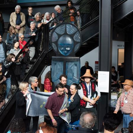 a crowd of people line the stairs while watching an art dedication ceremony